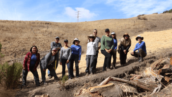 A group of volunteers pose for a photo at Furtado Barn during a Land Steward volunteer event