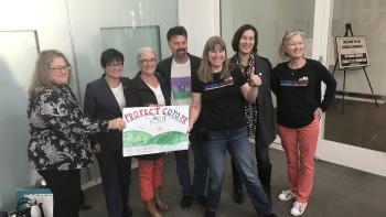 OSA Staff and supporters hold a protect Coyote Valley sign outside City Hall