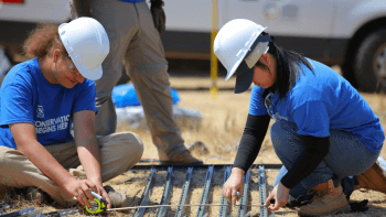 Two Student Conservation Students work on building a cattle grazing fence