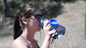 Hiker drinks water from a water bottle