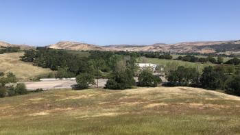 A view from Spreckels Hill of golden and green hills and trees