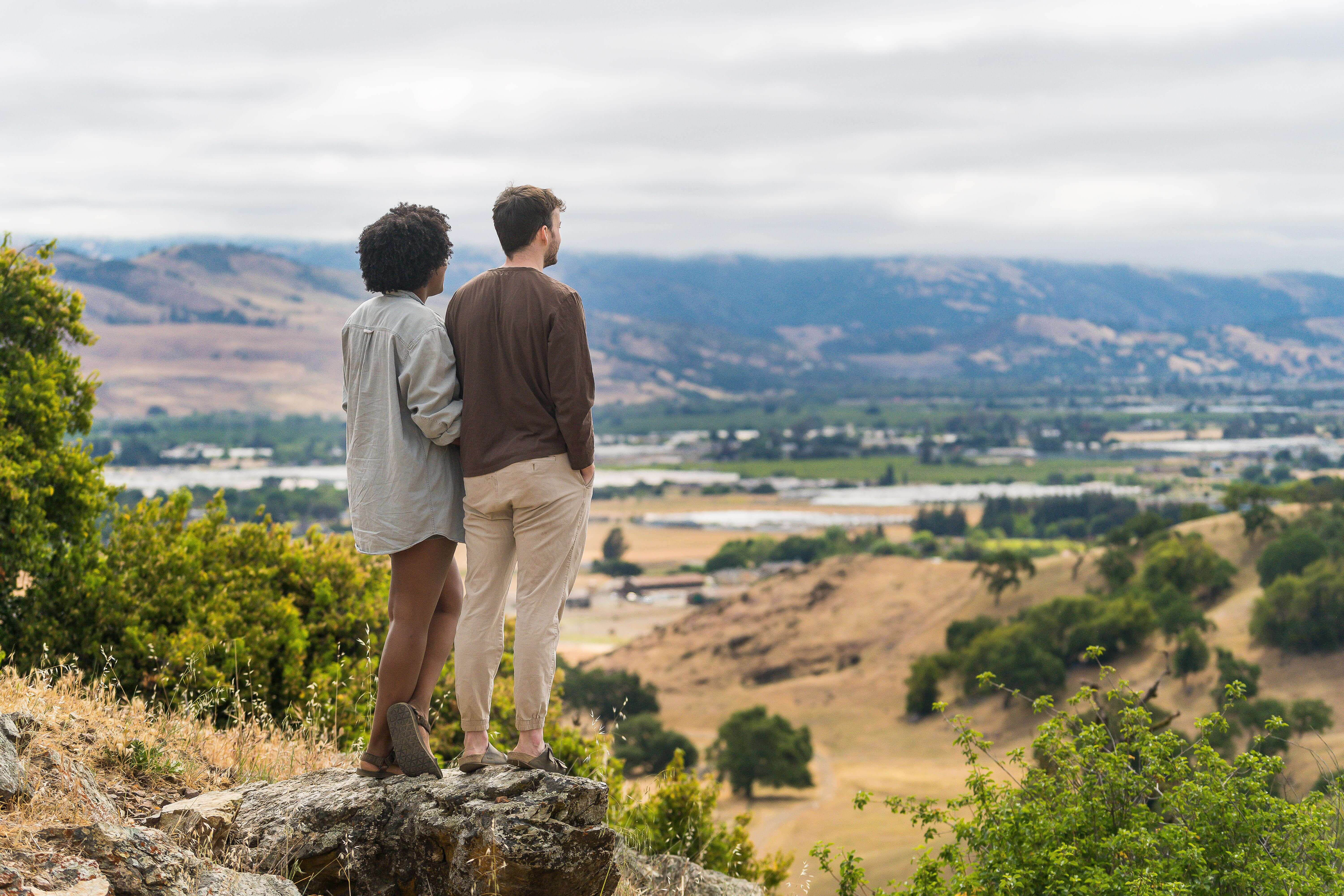 2 hikers with their backs to the camera overlooking a vista