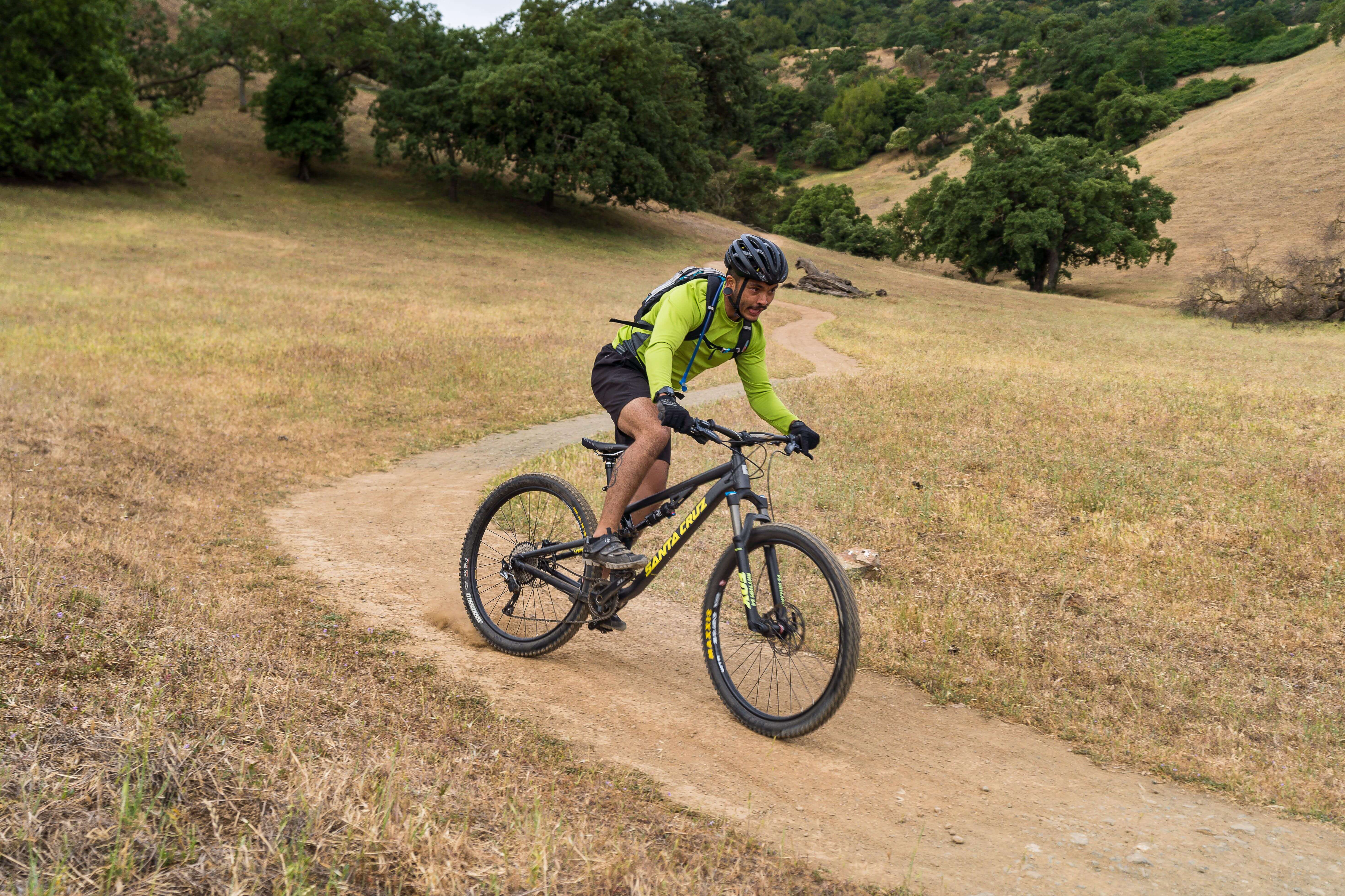 mountain biker in fluorescent green shirt on dirt trail