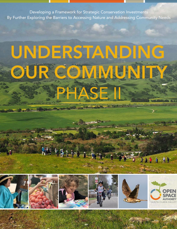 Report cover with yellow text that says "Understanding Our Community: Phase II" over an image of a beautiful green landscape with hikers walking along a ridge and a college below of people and animals