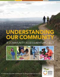 Report cover with yellow text that says "Understanding Our Community" over an image of a beautiful green landscape with hikers walking along a ridge and a college below of people in nature