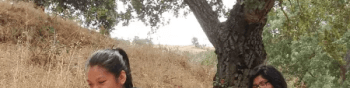 Two hikers traverse the Arrowhead Trail at Coyote Valley Open Space Preserve. They are both wearing gray sweaters, black leggings and hiking shoes.