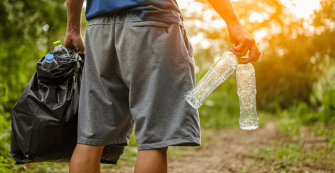 Person carrying trash and empty water bottles out of a nature preserve