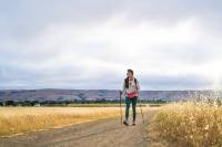 hiker with walking sticks on dirt trail